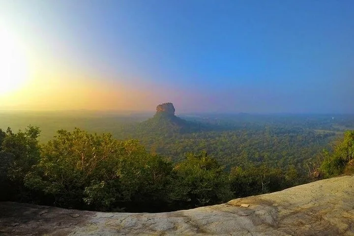 Vue panoramique de la forteresse du rocher de Sigiriya entourée d'une forêt dense au lever ou au coucher du soleil.